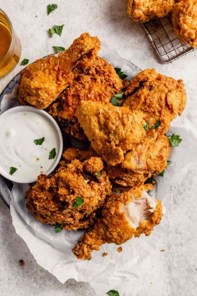 Golden brown fried chicken served on a plate with a side of mashed potatoes and coleslaw.